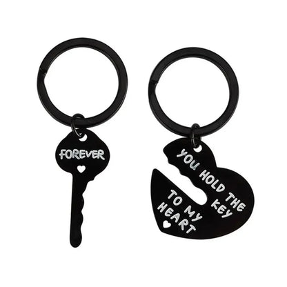 Black key and heart-shaped keychain with engraved text on a white background